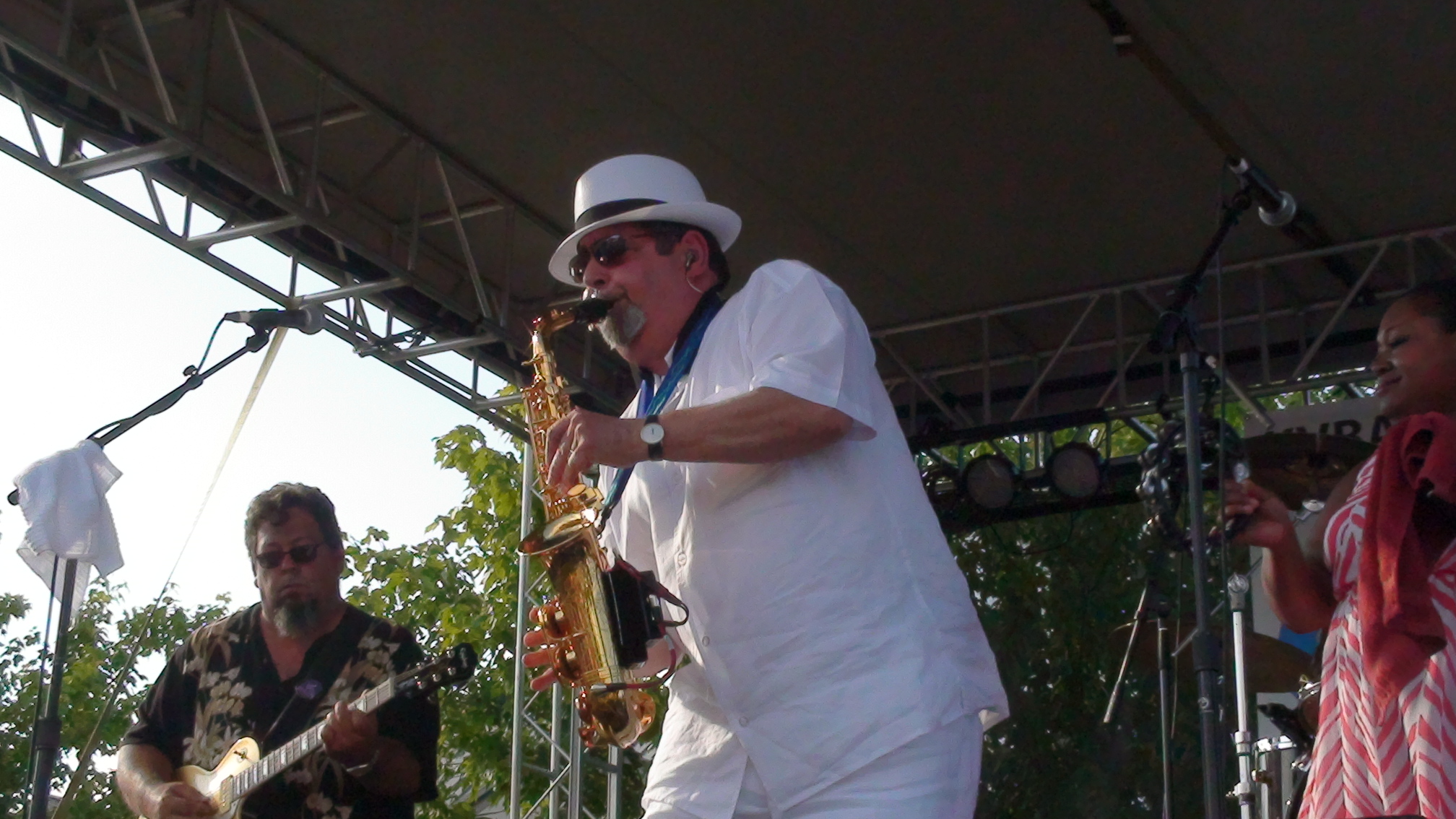 The full Sax Magic band performing live under a stage canopy at a festival