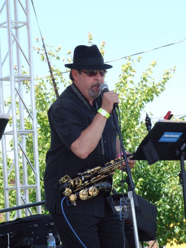 Bob Hunt singing into the microphone at an outdoor daytime gig