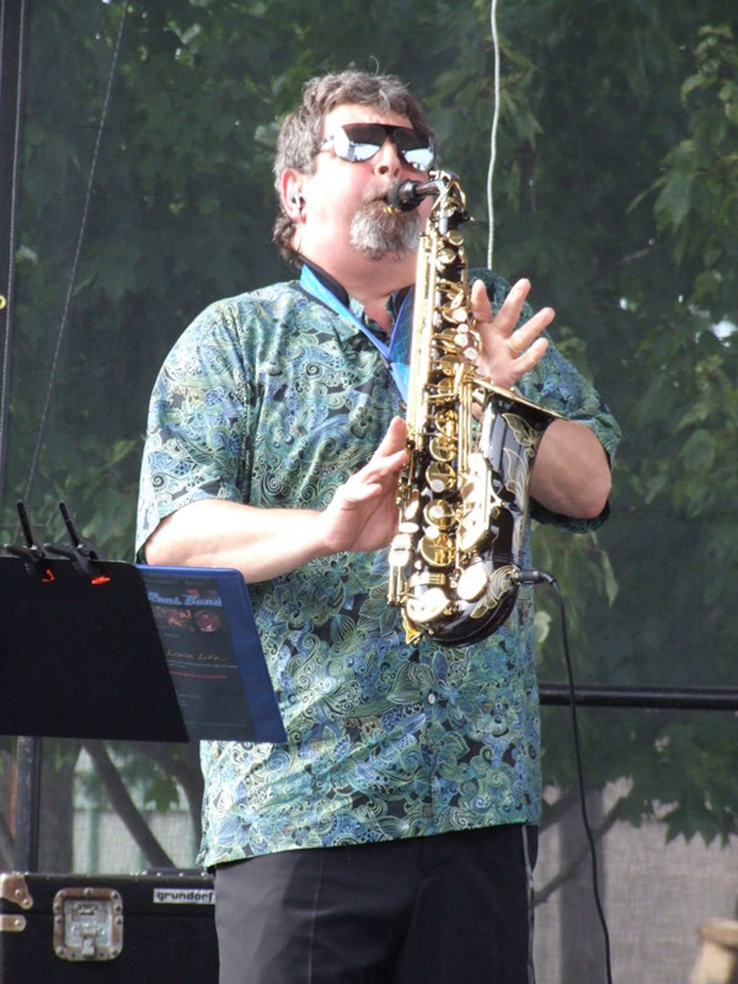 Bob Hunt in sunglasses playing saxophone outdoors at Bluesfest 2011